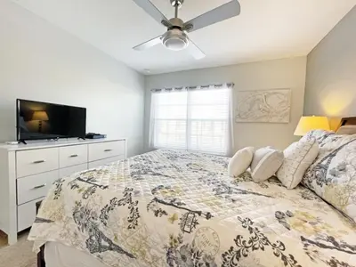 a bedroom with a bed and a ceiling fan at Candy Palm townhouse in Kissimmee
