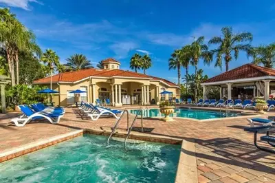 a swimming pool with chairs and a house at Sunshine Villa villa in Kissimmee
