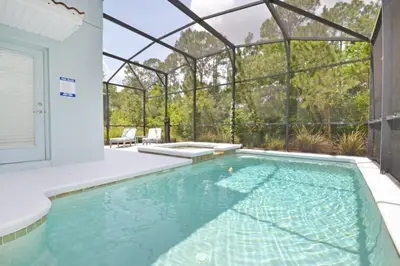 an indoor swimming pool with a glassconservatory at Bamboo Palm home in Kissimmee