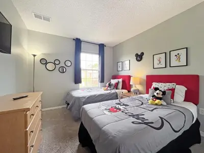 a bedroom with two beds and a red headboard at Pompano Place townhouse in Kissimmee