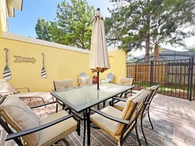 a patio with a table and chairs and an umbrella at Pompano Place townhouse in Kissimmee