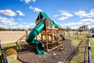a playground with a green slide in a yard at Beautiful & Cozy 4bd Home, Gated Community in Kissimmee
