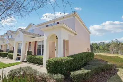 a white house with bushes in front of it at Veteran Owned 3bdr/3 bath Townhouse w/WiFi 3mi to Disney - Winter/Spring Specials in Kissimmee