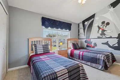a bedroom with two beds and a mickey mouse mural at Veteran Owned 3bdr/3 bath Townhouse w/WiFi 3mi to Disney - Winter/Spring Specials in Kissimmee