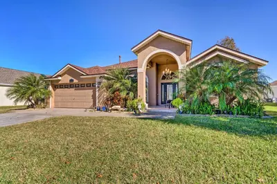 a large house with palm trees in front of it at Clermont Vacation Rental with Pool 11 Mi to Disney in Orlando