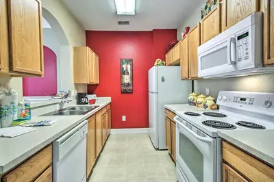 a kitchen with white appliances and a red wall at Resort Condo in Kissimmee about 3 Mi to Disney! in Orlando