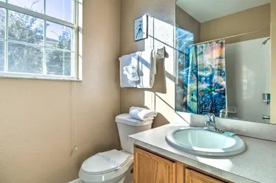 a bathroom with a sink and a toilet and a window at Resort Condo in Kissimmee about 3 Mi to Disney! in Orlando
