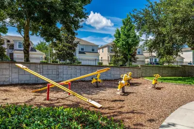 a playground with yellow play equipment in a park at Resort Condo in Kissimmee about 3 Mi to Disney! in Orlando