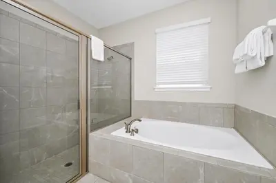 a bathroom with a bath tub and a shower at Alluring Home Near Disney With Themed, Media And Game Room With Waterpark & Resort Access At Encore Resorts Reunion - 232Au in Kissimmee
