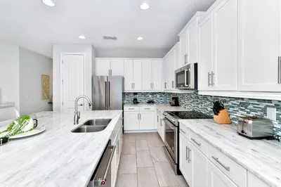 a kitchen with white cabinets and stainless steel appliances at Modern Home With Private Pool Near Disney With Waterpark & Resort Access At Encore Resort - 7655Ff in Kissimmee