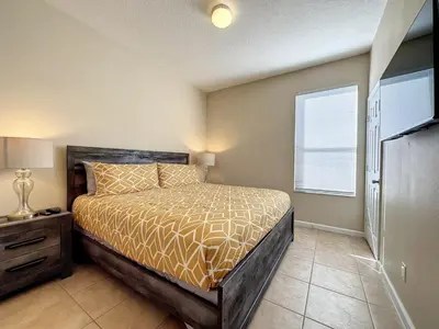 a bedroom with a bed and a window at Luxury 6BD 3,5BA Pool Home in Windsor Palms Resort villa in Kissimmee