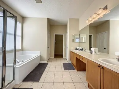 a bathroom with a tub and two sinks and a bath tub at Luxury 6BD 3,5BA Pool Home in Windsor Palms Resort villa in Kissimmee
