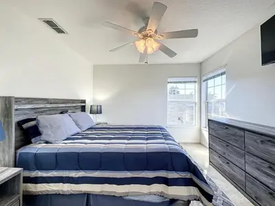 a bedroom with a bed and a ceiling fan at Luxury 6BD 3,5BA Pool Home in Windsor Palms Resort villa in Kissimmee