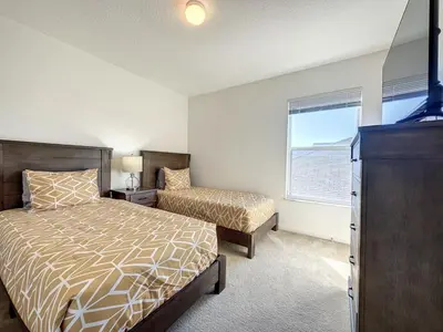 a bedroom with a bed and a dresser and a window at Luxury 6BD 3,5BA Pool Home in Windsor Palms Resort villa in Kissimmee