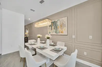 a dining room with a white table and white chairs at Amazing Story Lake Town Home With Pool townhouse in Kissimmee