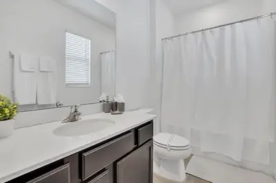 a white bathroom with a sink and a toilet at The Ultimate New 15 Bedroom 16 Bathroom Vernada villa in Kissimmee
