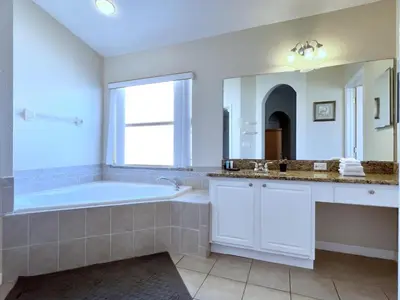 a bathroom with a tub and a large mirror at Lovely Lakeside 4-Bed Pool Home at Villa Sol-3125 home in Kissimmee