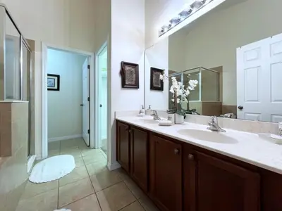 a bathroom with two sinks and a large mirror at Cozy 4 Bed 3 Bath Pool Hm with Game Room-4450NP home in Kissimmee