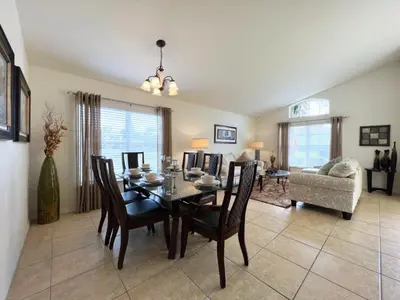 a dining room and living room with a table and chairs at Cozy 4 Bed 3 Bath Pool Hm with Game Room-4450NP home in Kissimmee
