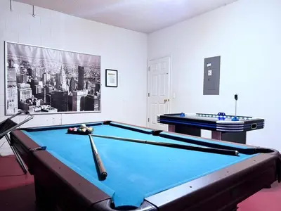 a room with a pool table and a picture of a city at Spacious 7Bd Pool Gm Hm Terra Verde Resort-211HBL home in Kissimmee