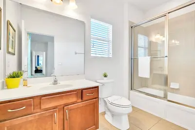 a bathroom with a toilet and a sink and a shower at 6BR Luxury Home w Pool Hot Tub and Games room in Kissimmee