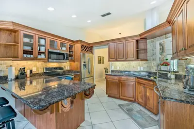 a large kitchen with wooden cabinets and granite counter tops at Walk to Lake Stunning Central Florida Home! in Lake Mary