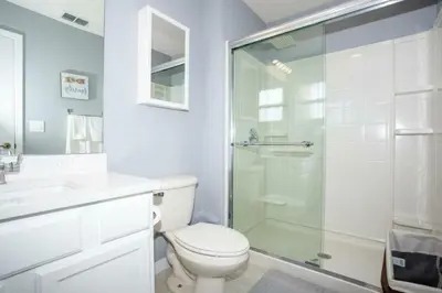 a bathroom with a toilet and a glass shower at Amazing 3 Bdrms At Encantada- 6 miles from Disney in Kissimmee
