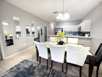 a kitchen and dining room with a table and chairs at Comfortable Apart 4Bdrm3Bath- 4 miles to Disney in Orlando
