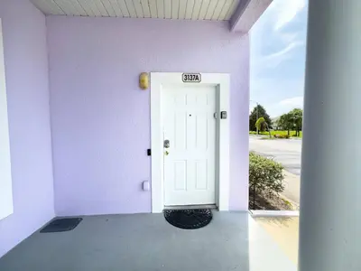 a purple building with a white door with a sign on it at Comfortable Apart 4Bdrm3Bath- 4 miles to Disney in Orlando