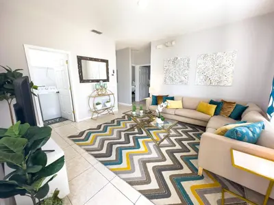 a living room with a couch and a rug at Comfortable Apart 4Bdrm3Bath- 4 miles to Disney in Orlando