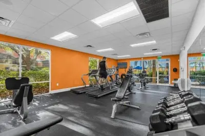 a gym with rows of tread machines and orange walls at Cozy 3Bdrms At Encantada- 6 miles from Disney in Kissimmee