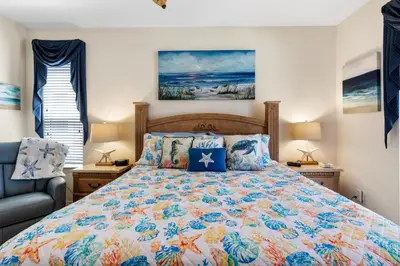 a bedroom with a large bed and a chair at Family Friendly Emerald Island Resort Vacation Home with Private Pool and Spa Near Disney in Kissimmee