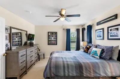 a bedroom with a bed and a ceiling fan at Family Friendly Emerald Island Resort Vacation Home with Private Pool and Spa Near Disney in Kissimmee