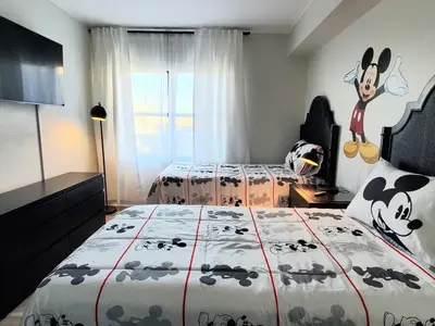 a bedroom with two beds and a cow on the wall at Remodeled 2BD/2BA Condo mins from Universal Studio in Orlando