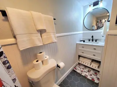 a bathroom with a toilet and a sink and a mirror at Remodeled 2BD/2BA Condo mins from Universal Studio in Orlando
