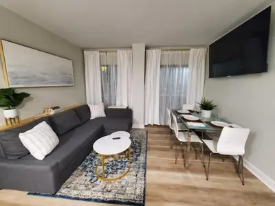 a living room with a black couch and a table at Remodeled 2BD/2BA Condo mins from Universal Studio in Orlando