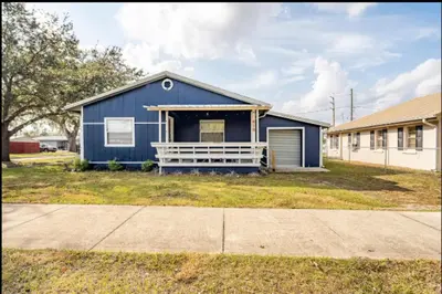 a blue house with a garage in a yard at 3-Bed Bungalow walk to Historic Downtown Sanford in Sanford