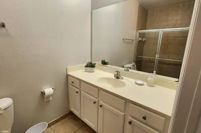 a bathroom with a sink and a mirror and a toilet at Apartment Kissimmee - Orlando in Kissimmee
