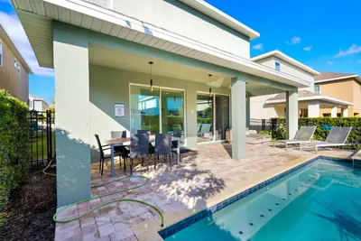 a house with a swimming pool and a dining area at Delightful Home Near Disney With Private Pool And Waterpark & Resort Access At Encore Resorts Reunion - 441No in Kissimmee