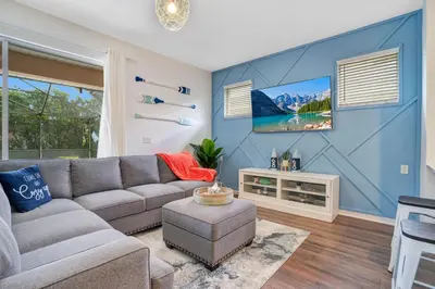 a living room with a gray couch and a blue wall at Yelleville on Sunset! 4 Miles to Disney in Kissimmee