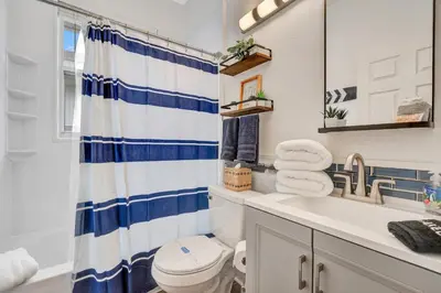 a bathroom with a blue and white shower curtain and a toilet at Yelleville on Sunset! 4 Miles to Disney in Kissimmee