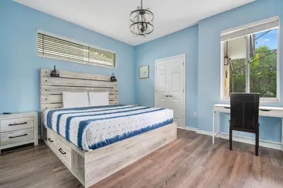 a bedroom with blue walls and a bed and a desk at Yelleville on Sunset! 4 Miles to Disney in Kissimmee
