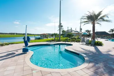 a pool at a resort with a palm tree at 7 BR Large Pool Game Room @ Storey Lake SL2861 in Kissimmee
