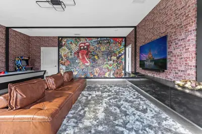 a living room with a brown couch and a brick wall at 7 BR Large Pool Game Room @ Storey Lake SL2861 in Kissimmee