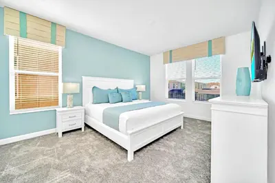 a bedroom with a white bed and two windows at Upstay 6BR Resort Home w Pool & Basketball Court in Kissimmee