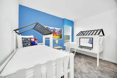 a bedroom with a white bed and a desk at Upstay 6BR Resort Home w Pool & Basketball Court in Kissimmee