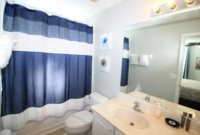 a bathroom with a sink and a toilet and a mirror at Emerald Island Escape- Pool and spa in Kissimmee