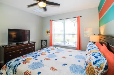 a bedroom with a bed and a flat screen tv at Emerald Island Escape- Pool and spa in Kissimmee