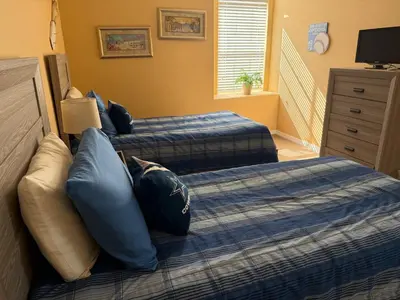 a bedroom with two beds with blue pillows at Luxury 5 Bedroom Villa with Secluded Pool/Spa in Glenbrook community near Orlando in Orlando