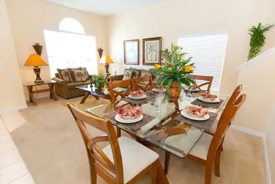 a dining room and living room with a table and chairs at Luxury 5 Bedroom Villa with Secluded Pool/Spa in Glenbrook community near Orlando in Orlando